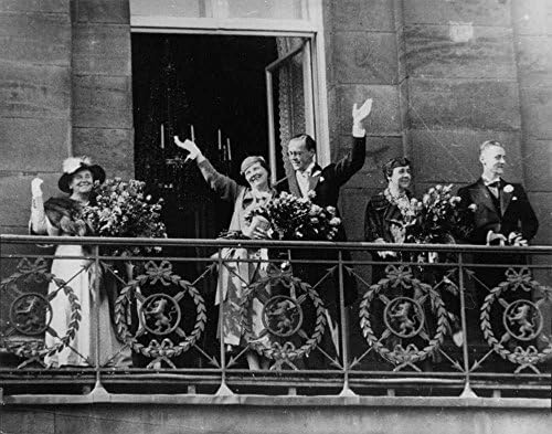 Гроздобер фотографија на Julулијана стои и мавта со толпата од балконот по нејзината свадба.