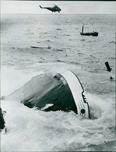 Гроздобер фотографија на водно возило што тоне во вода и хеликоптер дојде да ги спаси луѓето во Шпанија.